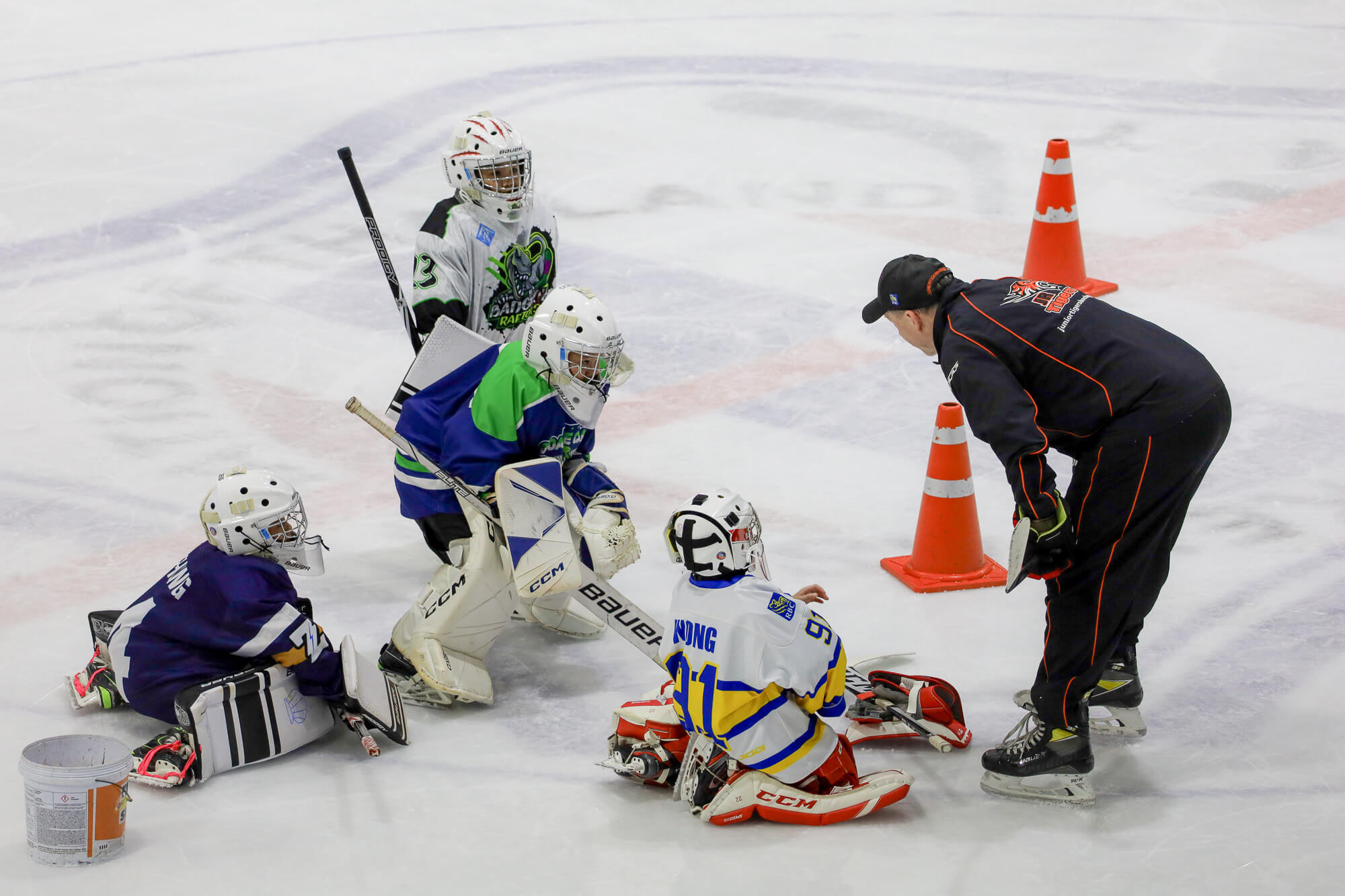 A Coach training young goalies